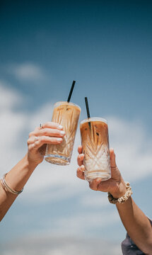 Two people are holding up their drinks in a toast