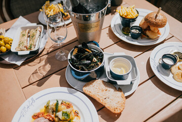 A table with a variety of food and drinks, including a sandwich, a bowl of soup