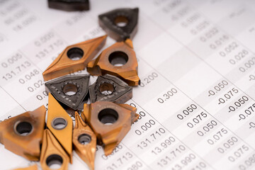 Metal cutting tools arranged on a technical data sheet with measurements in a workshop environment