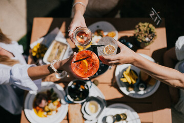 A group of people are celebrating with drinks and food