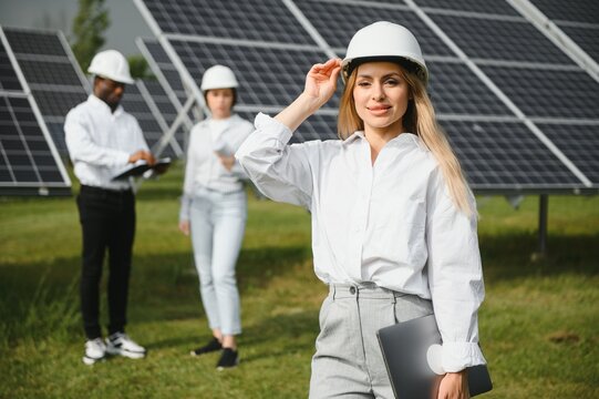 Male and female engineers worker working in solar panels power farm. technician working at solar power station