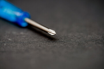 Close-up view of a screwdriver on a black surface showcasing its precision and design elements