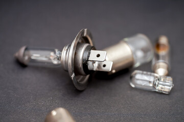 Detailed view of various automotive light bulbs and connectors on a dark surface
