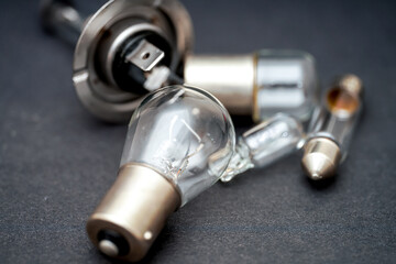Collection of various glass light bulbs and components on a dark surface during the day