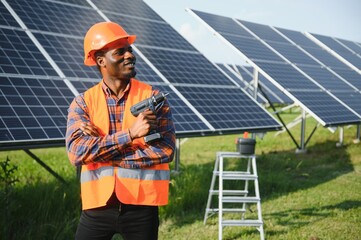 Portrait of african american electrician engineer in safety helmet and uniform installing solar...