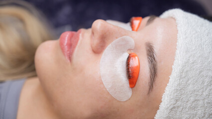 Caucasian woman undergoing eyelash lamination procedure. 