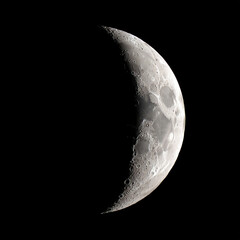 Naklejka premium Detailed crescent moon phase showing craters and surface texture in the darkness of space isolated on transparent background