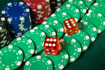 Players engage in a thrilling game as vibrant casino chips and dice are spread across a green felt table, creating a lively atmosphere in the gaming room