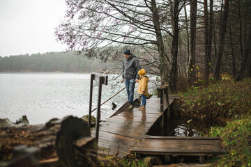 Heartwarming moment between father and child on the dock of Balzis Lake in Lithuania, surrounded by...