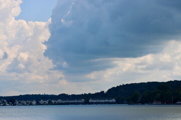 Vast Lake Under a Bright Sky With Scattered Fluffy Clouds Reflecting on Serene Water in a Peaceful Natural Setting During Daytime