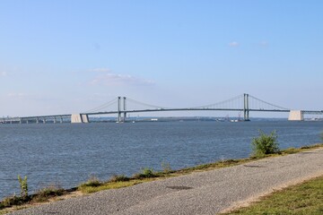 Stunning View of a Modern Bridge Spanning a Serene River Under a Bright Blue Sky on a Calm Day, Inviting Travelers and Nature Lovers Alike to Enjoy the Landscape