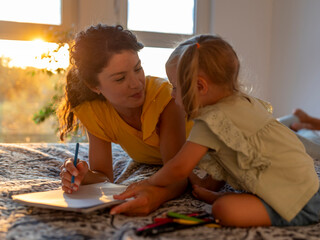 Mother and daughter enjoy drawing together indoors