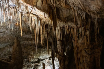 Majestic stalactites in an ancient cave illuminated by subtle glow