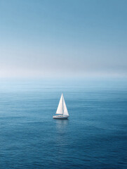 Fototapeta premium Solitary sailboat on calm, deep blue sea under pale sky. Evokes peace, freedom, escape, and adventure. Perfect for travel, lifestyle, or inspirational themes. Serene, minimal.