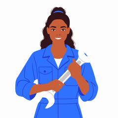Fototapeta premium A smiling woman with dark hair in a blue jumpsuit, confidently holding a large wrench.