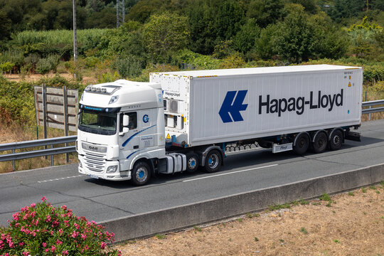 White daf xf truck carrying hapag-lloyd reefer container driving on highway