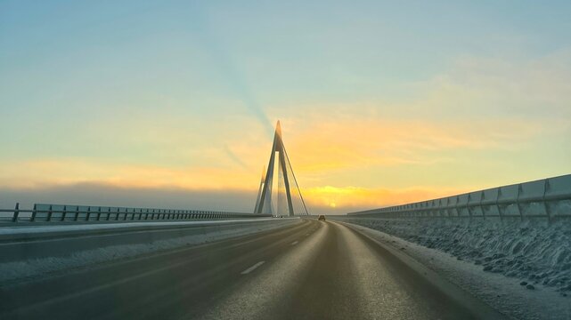 A breathtaking view of the iconic Uddevalla Bridge (Uddevallabron) enveloped in a crisp, icy winter morning glow.