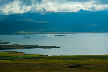 Obraz premium Icelandic Ocean Coastline with Mountains and Small Islands