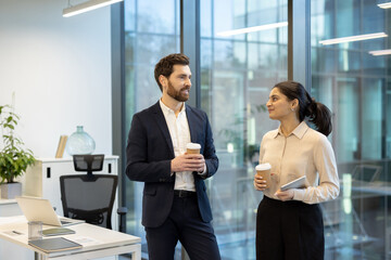 Business professionals discussing in a modern office setup over coffee
