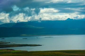 Iceland Ocean Bay with Green Coast and Cloudy Mountains