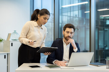 Two colleagues collaborating on a project during an office work session