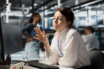 Pensive server hub engineer looking at data visualization on PC, thinking how to fix performance...