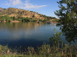 Mountain Lake with Boats and Hillside View