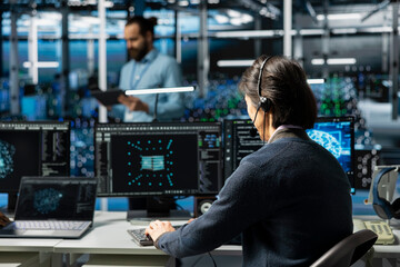 Admin in data center speaks in headset mic, troubleshooting rigs connectivity issues using AI. IT expert doing tech support in server hub, talking in remote call, auditing systems for vulnerabilities