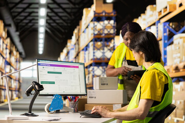 African american supervisor asking asian man about the delivery status, discussing about tracking info on a distribution software. E commerce warehouse relies on smart logistics systems.
