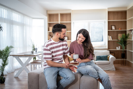 Young couple relaxing at home, reading and enjoying coffee