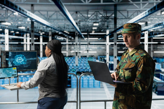 Team of army tech experts in data center conducting threat simulations using AI neural networks. Teamworking server farm colleagues using artificial intelligence supporting military operations