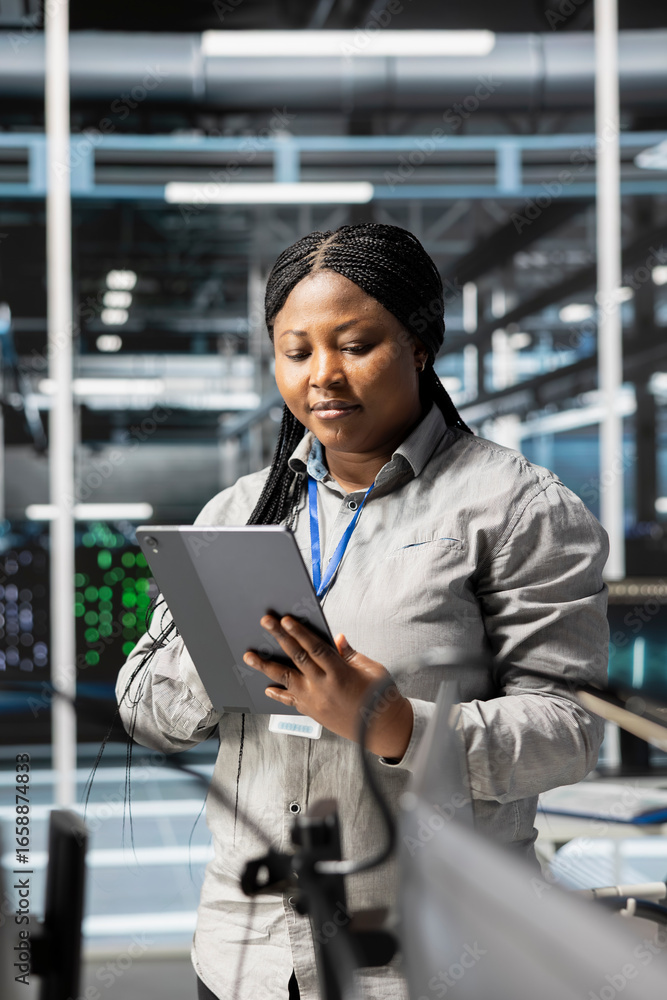 Poster woman in data center doing software updates, verifying deep learning parameters. african american se