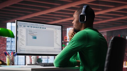 Freelance developer writing code in a modern programming language. Young man analyzes big data, algorithms and optimizing performance while using binary code at home office. Camera A.