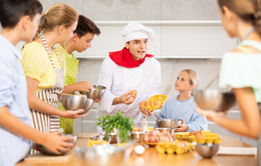 Friendly positive young guy, qualified chef, running culinary courses for group of tween children,...