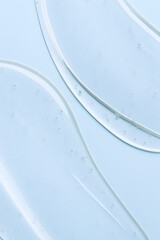 Cosmetic gel texture with bubbles on light blue background