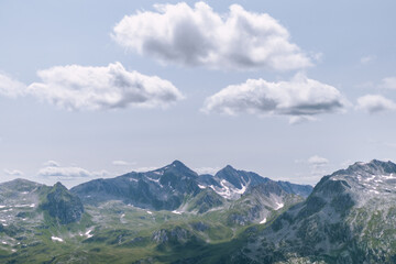 Fototapeta premium Alpine Wildnis: Beeindruckende Berggipfel mit Schneeresten im Sommer