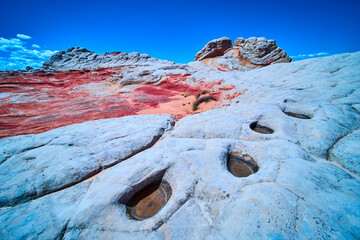 White Pocket sandstone formations with water pools and blue sky Arizona