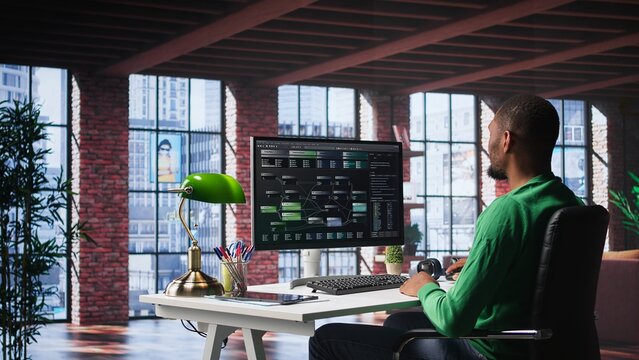 African american engineer at home working on visual coding on terminal window, typing programming language and reviewing the notes tree. IT expert using debugging algorithms to fix errors. Camera B.