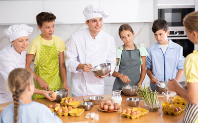 Teenage children are interested in learning in culinary courses under the supervision of two adult chefs