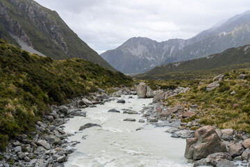 Flusslauf zwischen grünen Bergen im Gebirgstal
