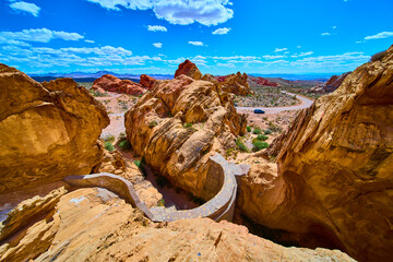 Whitney Pocket Red Rocks Stone Cistern and Winding Desert Road Under Blue Sky