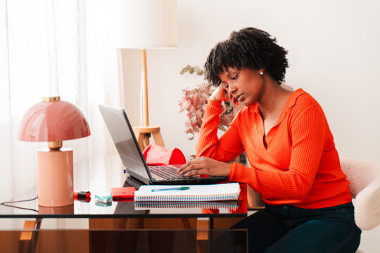 A young woman is deeply focused and somewhat frustrated while working on her laptop, illustrating the challenges and stress that students often face during their studies and personal endeavors in life