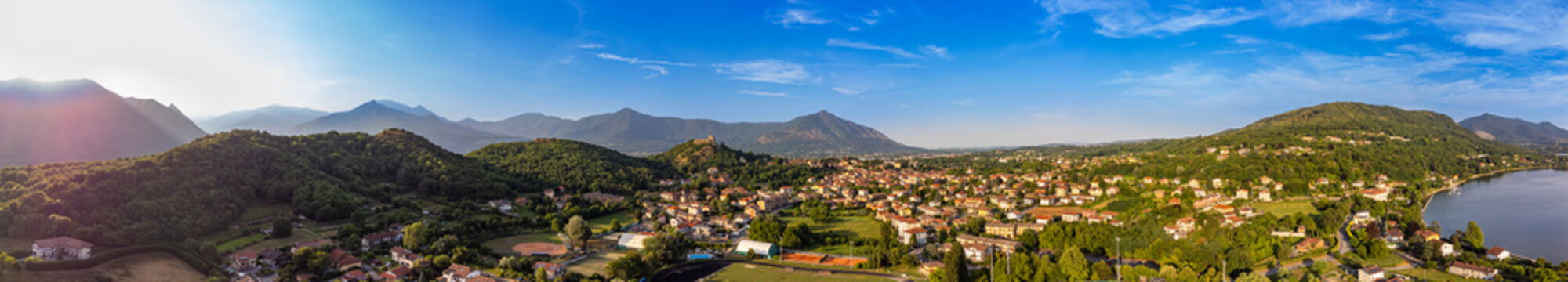 Aerial sunset view of Avigliana, Italy, Piedmont , Turin,Italy A beautiful town with a medieval castle and red-roofed houses, surrounded by the green hills of Susa and trees on a sunny day.