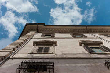 Upward perspective of traditional Roman residential building with classic architectural features