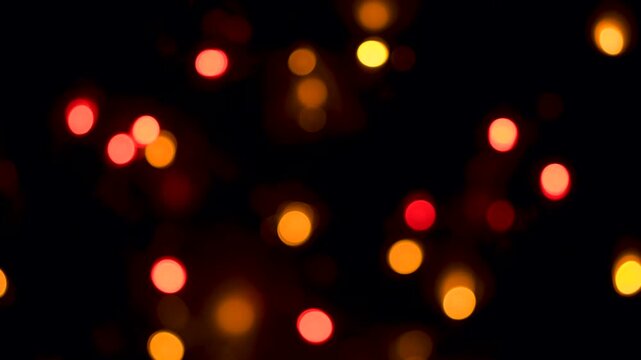 real life multicoloured bokeh with a dark black background as the camera passes over defocussed multi-coloured fairy lights softly twinkling in various sequence patterns 4K