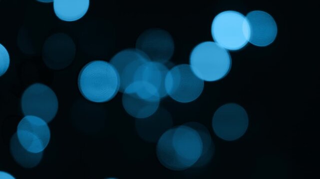 cool electric blue bokeh lights animate on screen with a sweeping arc and flash in a sequence with a cold arctic snowy Christmassy icy winter theme vibe 4K