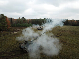 Aerial view of two artillery systems creating coordinated smoke screen deployment