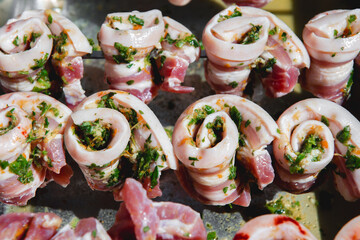 Marinated pork belly skewers with herbs prepared for grilling.