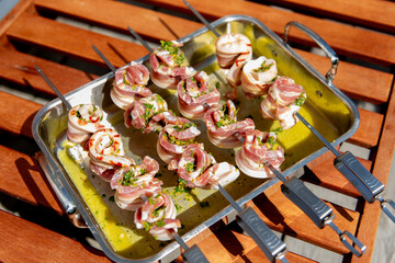 Marinated pork belly skewers with herbs prepared for grilling.