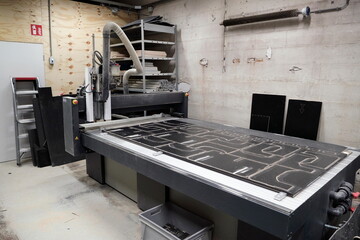 Complete CNC cutting machine setup in production facility with cut flight case panels visible